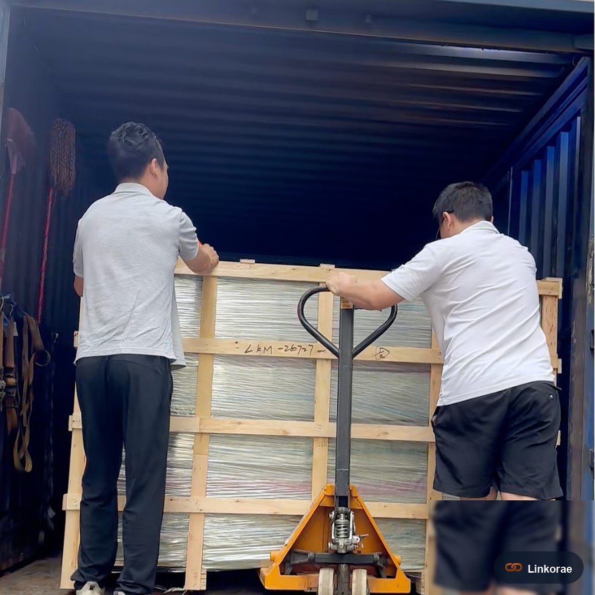 Crew rolling a wooden crate into a container at our Shenzhen warehouse